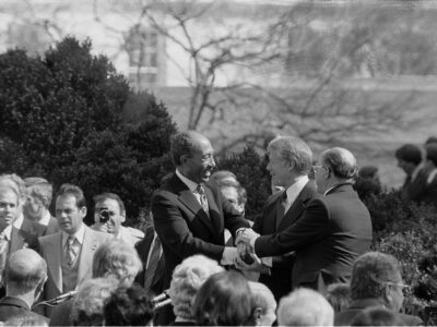 "Photograph shows President Jimmy Carter shaking hands with Egyptian President Anwar Sadat and Israeli Prime Minister Menachem Begin at the signing of the Egyptian-Israeli Peace Treaty on the grounds of the White House.